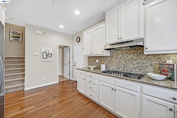 a kitchen with white cabinets and sink