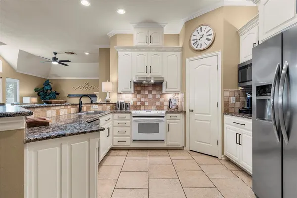 a kitchen with stainless steel appliances granite countertop a refrigerator and a stove top oven