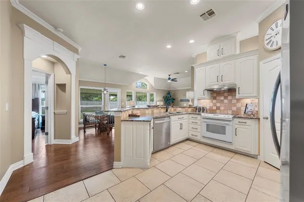 a kitchen with cabinets and wooden floor