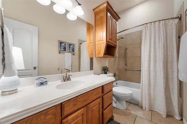 a bathroom with a sink a toilet a mirror and shower