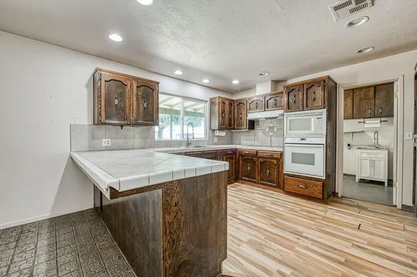 a spacious bathroom with a granite countertop sink mirror and a bathtub