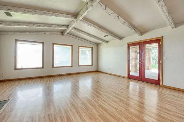 a view of empty room with wooden floor and fireplace