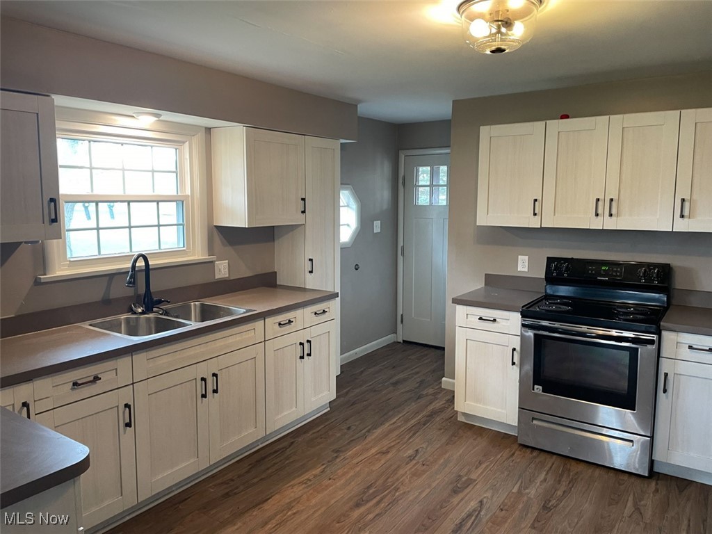855 Georgetown Road Salem, OH 44460 - Photo 9 of 28 Kitchen featuring electric range, dark wood-style flooring, a sink, dark countertops, and baseboards