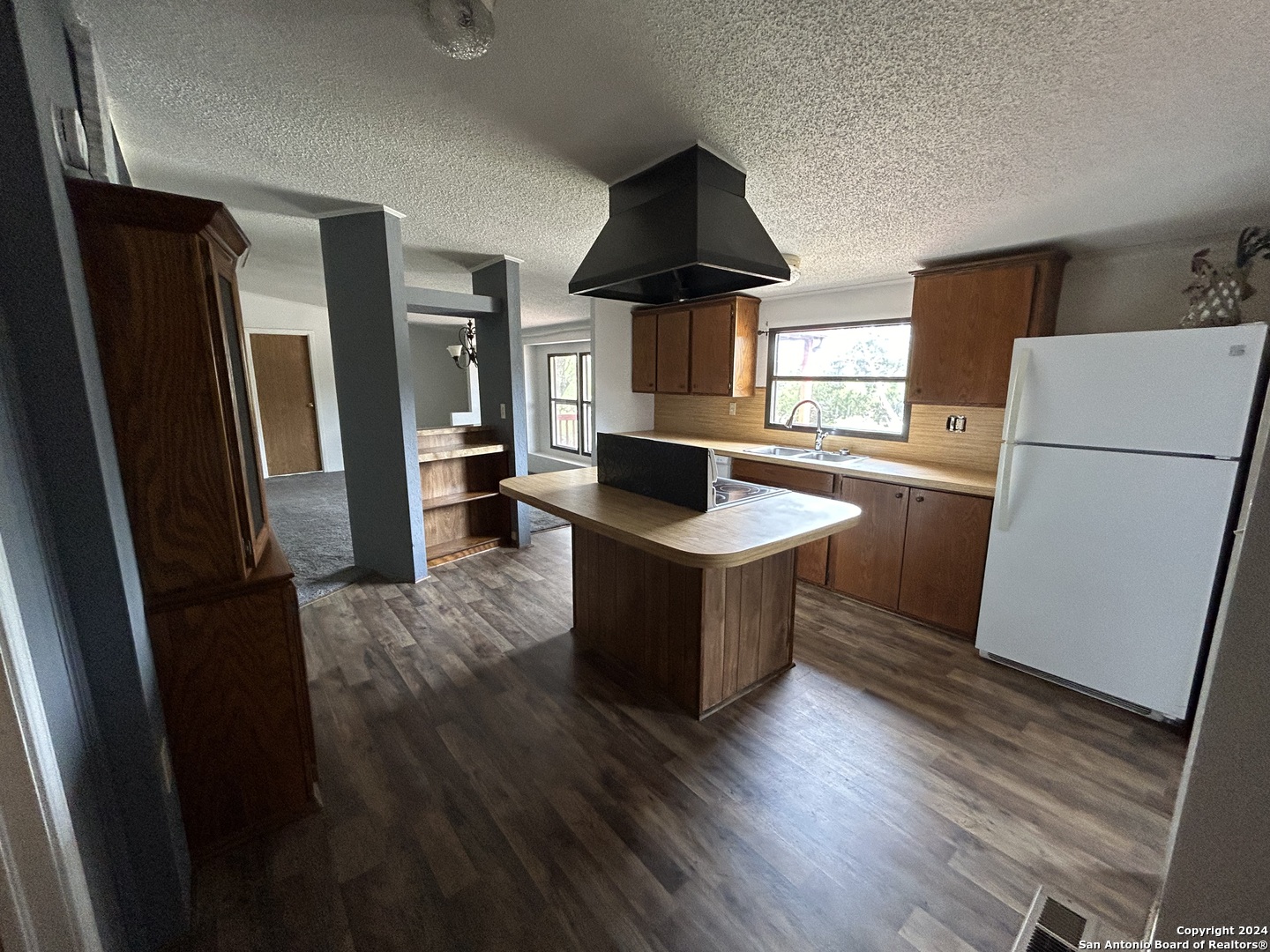 454 Overland Trail Bandera, TX 78003 - Photo 4 of 24 a kitchen with a refrigerator stove and wooden floor