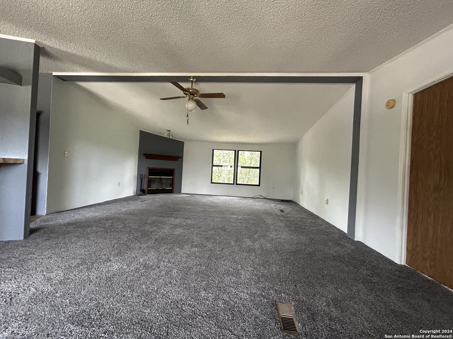 454 Overland Trail Bandera, TX 78003 - Photo 6 of 24 a view of a big room with windows and fireplace