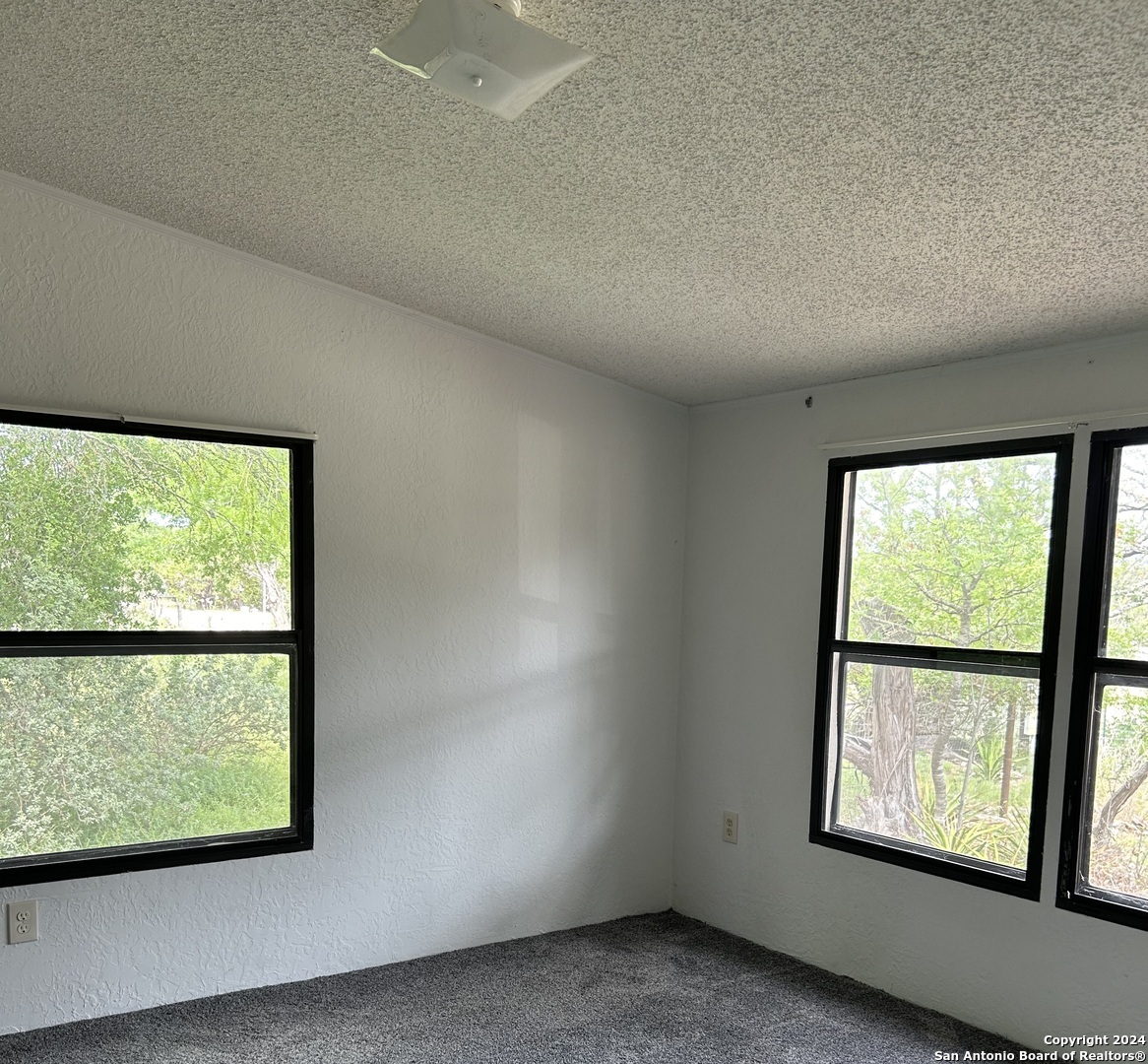 454 Overland Trail Bandera, TX 78003 - Photo 7 of 24 an empty room with large windows
