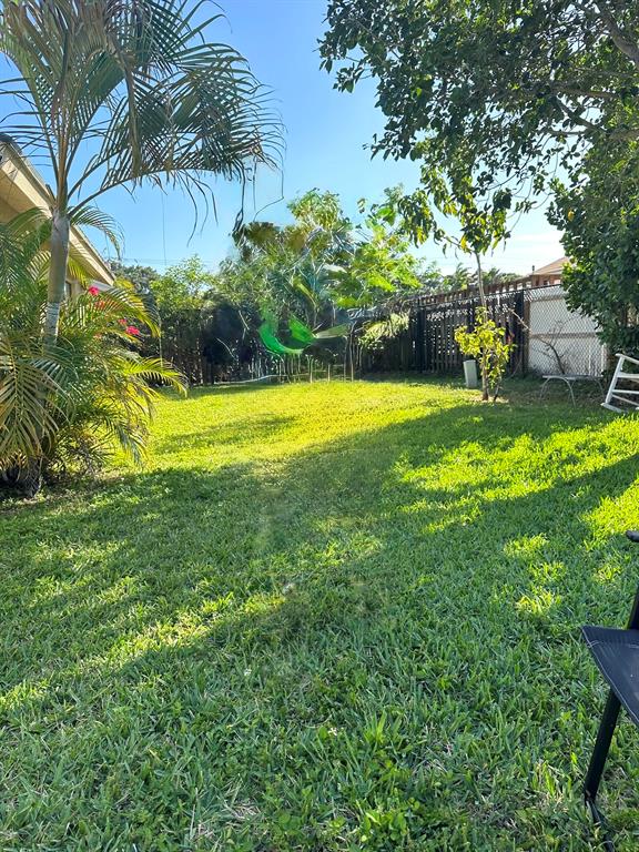 9138 Bedford Drive Boca Raton, FL 33434 - Photo 17 of 21 a view of a swimming pool with a garden and trees