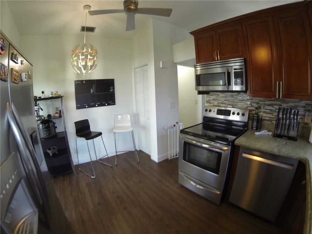 9138 Bedford Drive Boca Raton, FL 33434 - Photo 7 of 21 a kitchen with stainless steel appliances a stove microwave and refrigerator