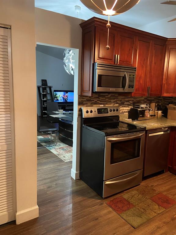 9138 Bedford Drive Boca Raton, FL 33434 - Photo 9 of 21 a kitchen with stainless steel appliances granite countertop a stove a sink and a microwave