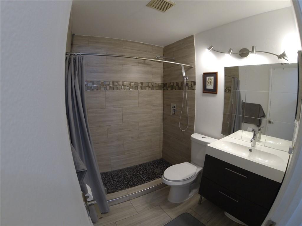 9138 Bedford Drive Boca Raton, FL 33434 - Photo 10 of 21 a bathroom with a toilet a sink and shower