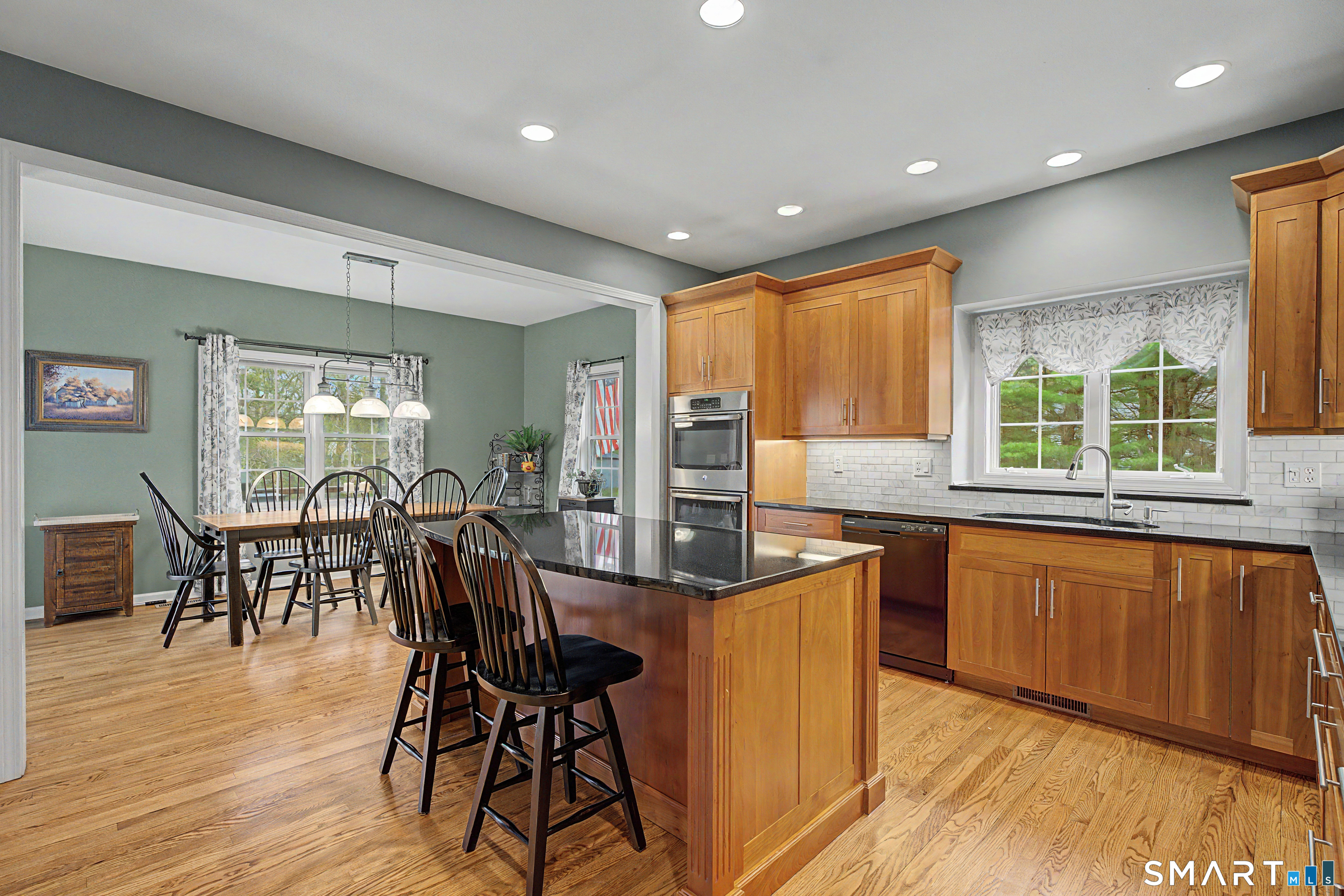 445 Dublin Road Southbury, CT 06488 - Photo 9 of 40 a kitchen with stainless steel appliances granite countertop dining table chairs wooden floors and white cabinets