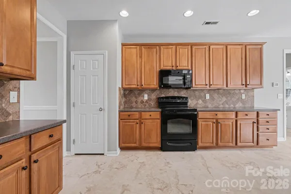 a kitchen with granite countertop a stove top oven sink and cabinets