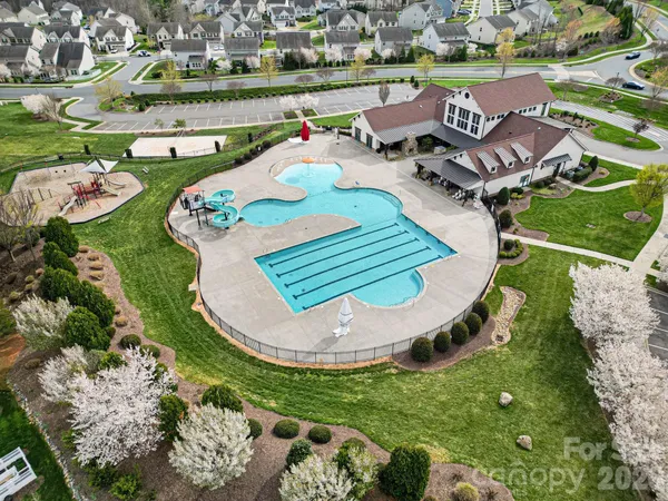 an aerial view of a house with outdoor space pool patio and lake view