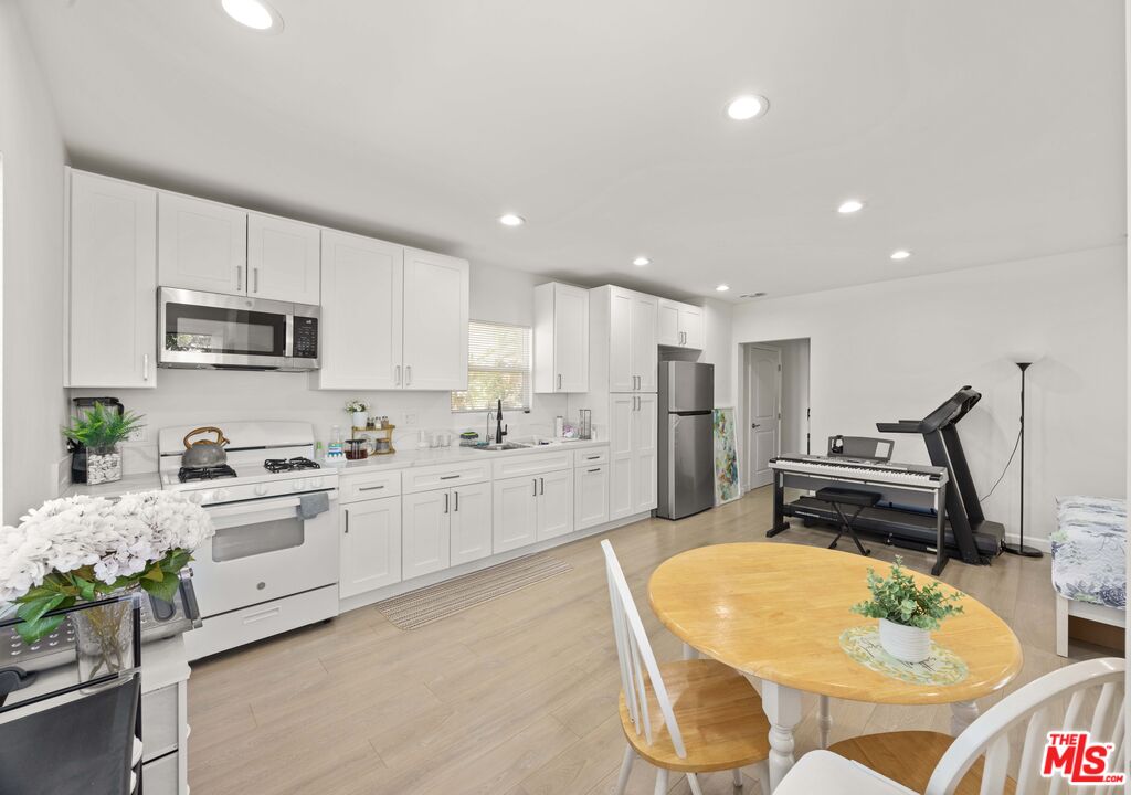 7752 Le Berthon Street Tujunga, CA 91042 - Photo 4 of 15 a kitchen with stainless steel appliances kitchen island granite countertop a sink a stove a refrigerator cabinets and chairs