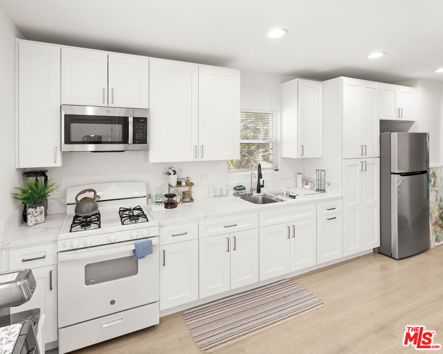 7752 Le Berthon Street Tujunga, CA 91042 - Photo 5 of 15 a kitchen with white cabinets white stainless steel appliances and sink