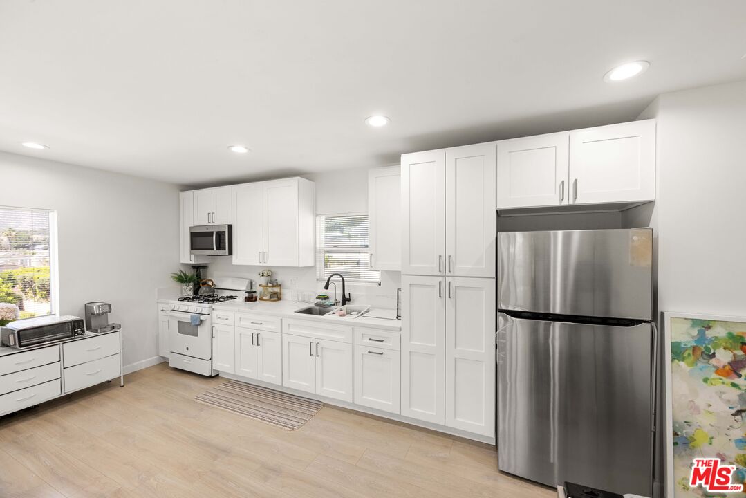 7752 Le Berthon Street Tujunga, CA 91042 - Photo 6 of 15 a kitchen with white cabinets and white appliances