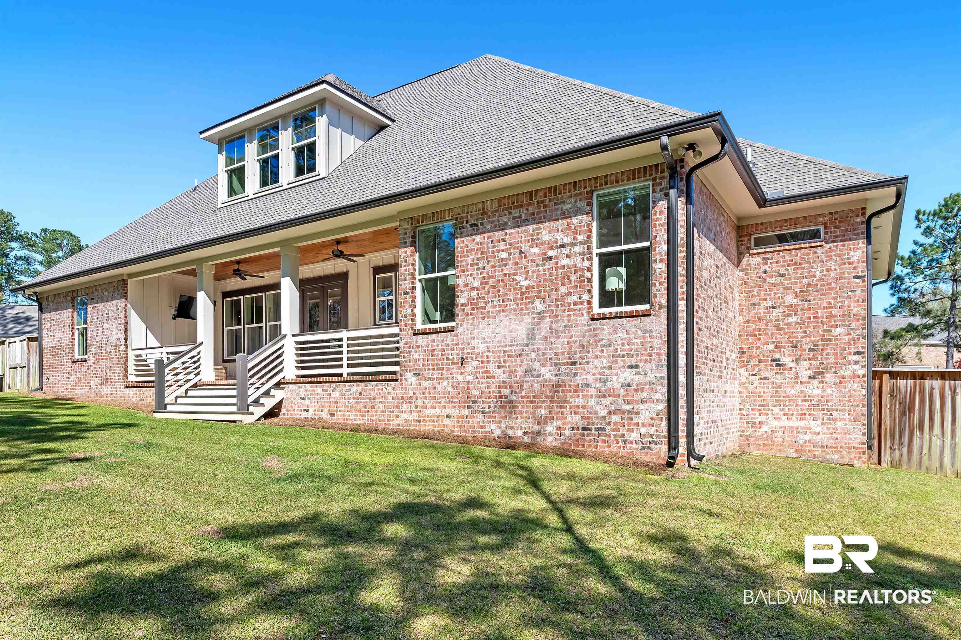 27888 Oakachoy Loop Daphne, AL 36526 - Photo 53 of 65 View of front facade featuring a ceiling fan, fence, brick siding, a front lawn, and a porch