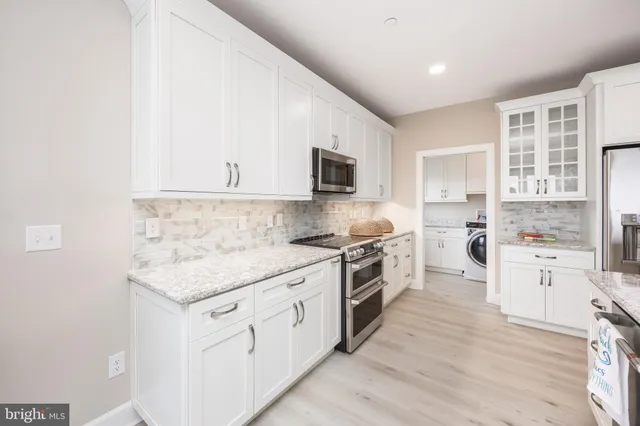 a kitchen with white cabinets and appliances