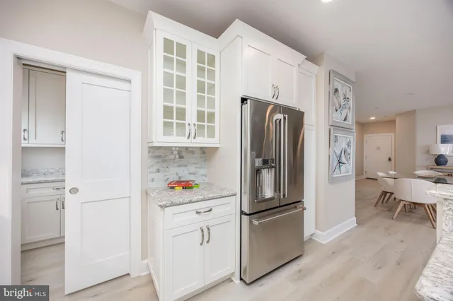 a kitchen with stainless steel appliances a refrigerator a stove a dining table and chairs