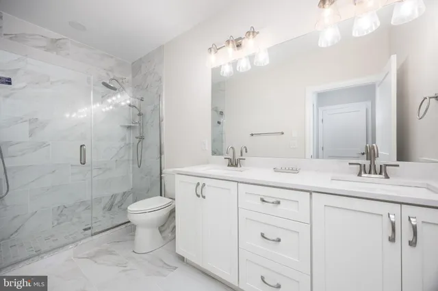 a bathroom with a double vanity sink mirror and toilet