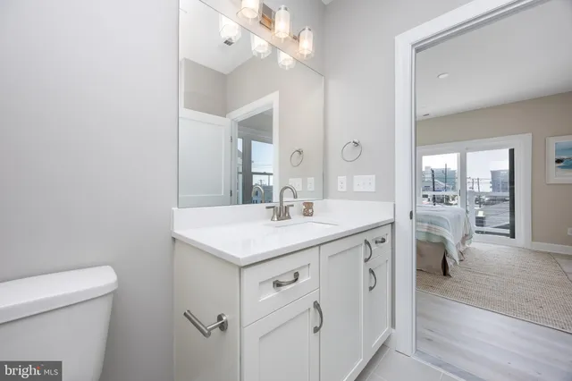 a spacious bathroom with a granite countertop sink a toilet and a mirror