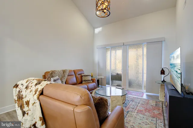 a living room with furniture a flat screen tv and a table