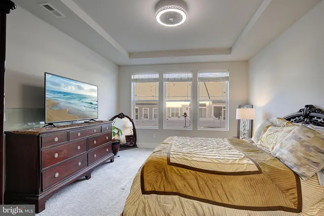 a bedroom with a bed and large windows