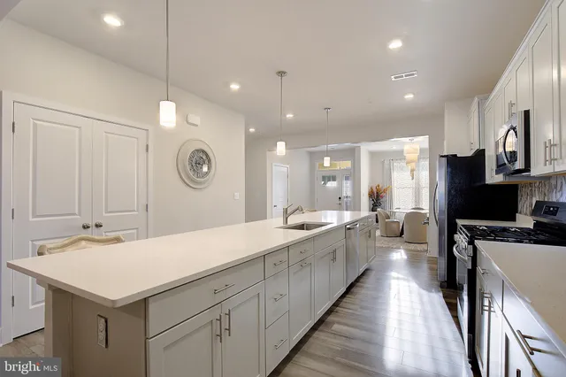 a large kitchen with kitchen island a sink appliances and a counter top space