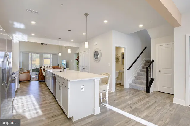 a large space with a large kitchen island wooden floor and a view of living room