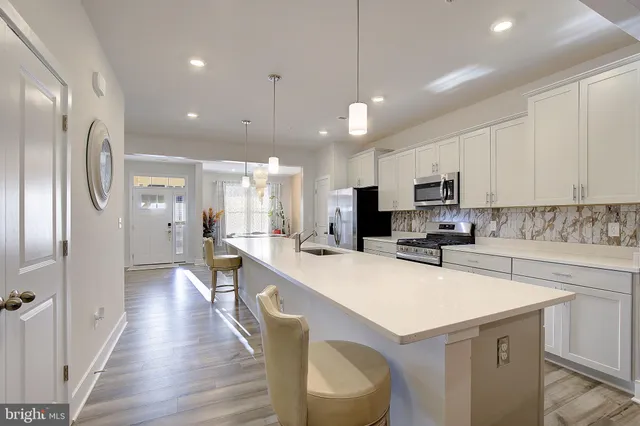 a kitchen with a sink a counter top space stainless steel appliances and cabinets