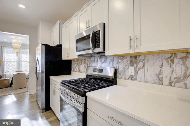 a kitchen with stainless steel appliances granite countertop a stove a microwave and a refrigerator
