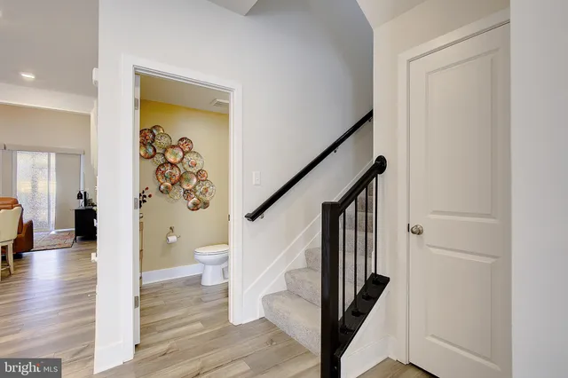 a view of a hallway with wooden floor and stairs