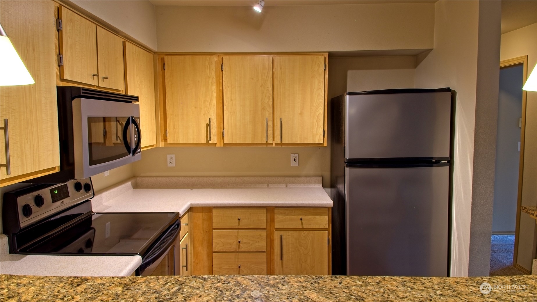 10709 Valley View Road, Unit A201 Bothell, WA 98011 - Photo 6 of 25 a kitchen with a refrigerator a stove and a microwave