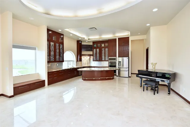 a kitchen with kitchen island granite countertop a sink and stainless steel appliances