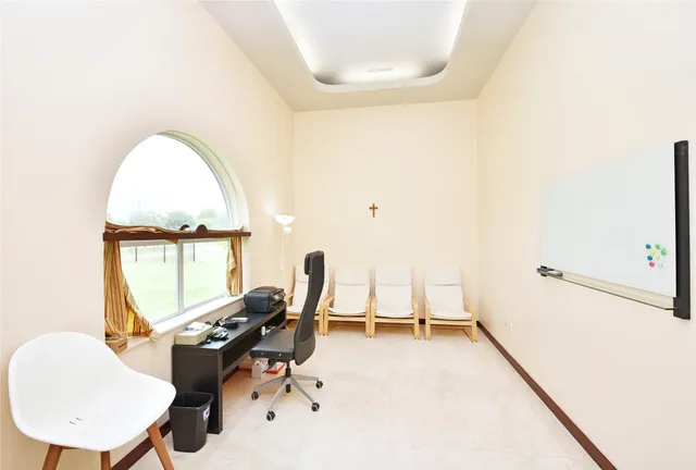 a view of a livingroom with workspace and a window