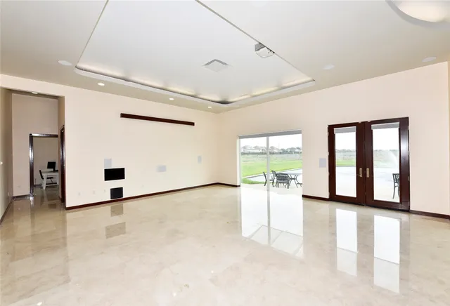 a view of a hall with a dining table chairs and couches with wooden floor