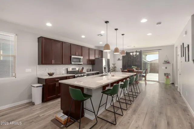 a kitchen with stainless steel appliances granite countertop table chairs sink and cabinets