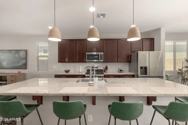 a kitchen with stainless steel appliances granite countertop a sink a stove a refrigerator and a cabinets