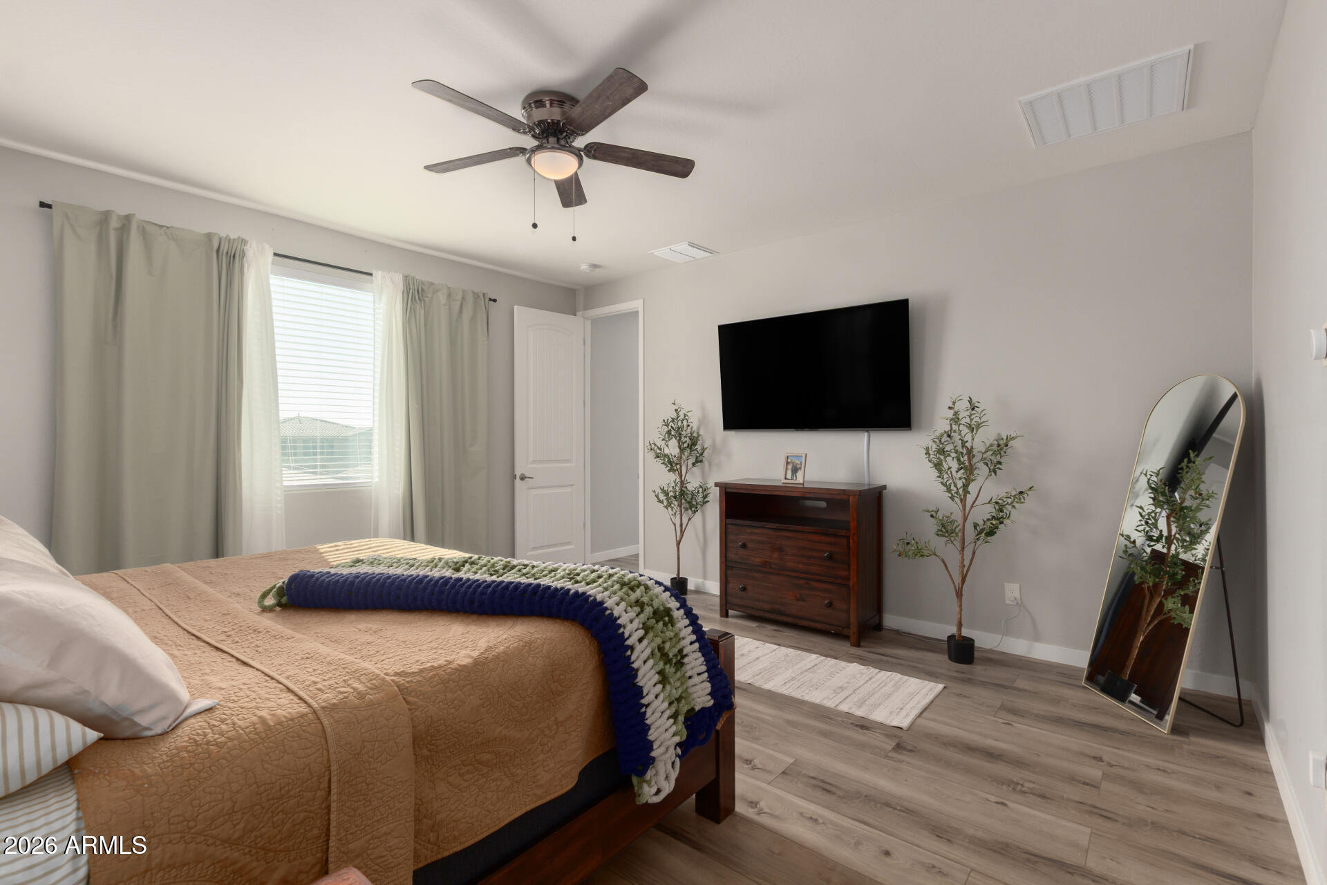21073 West Berkeley Road Buckeye, AZ 85396 - Photo 16 of 41 a bedroom with a bed and a flat screen tv