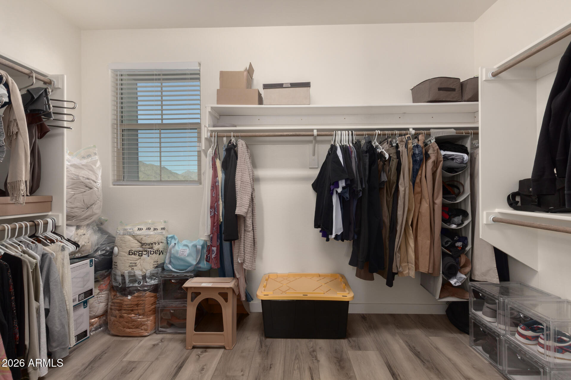 21073 West Berkeley Road Buckeye, AZ 85396 - Photo 22 of 41 a view of walk in closet with clothes and shoes