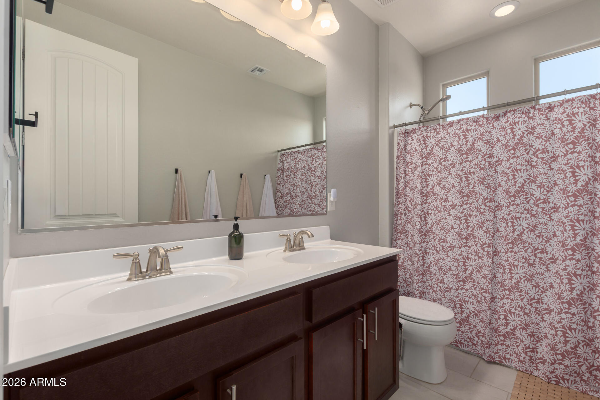 21073 West Berkeley Road Buckeye, AZ 85396 - Photo 25 of 41 a bathroom with a double vanity sink toilet and a mirror