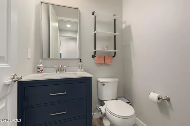 a bathroom with a toilet a sink a mirror and vanity