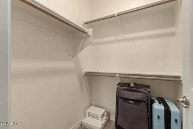 a view of walk in closet with clothes and shoes