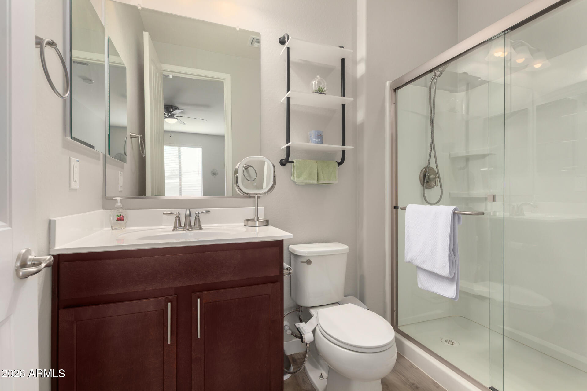 21073 West Berkeley Road Buckeye, AZ 85396 - Photo 35 of 41 a bathroom with a toilet a sink a glass door a shower and a mirror