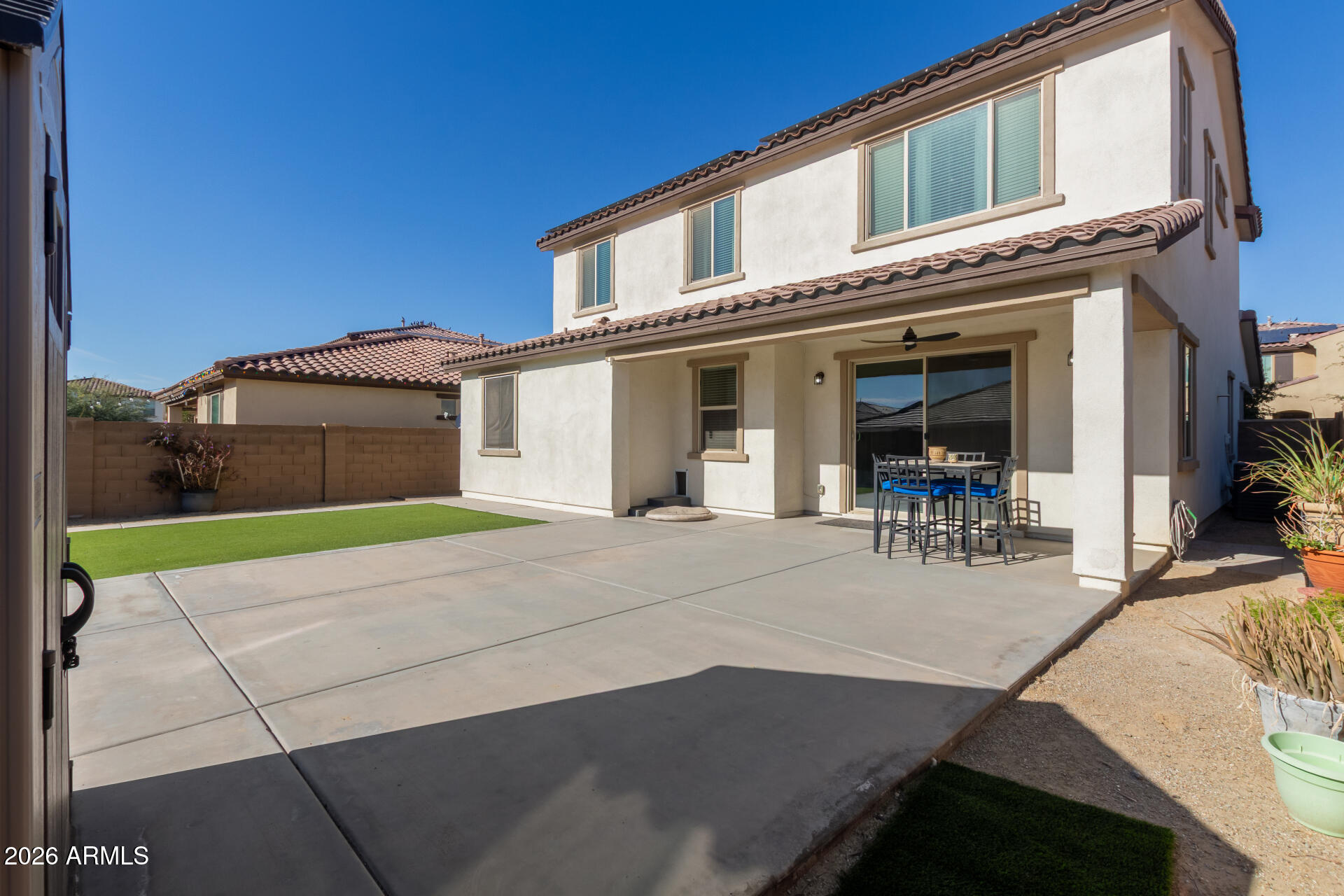 21073 West Berkeley Road Buckeye, AZ 85396 - Photo 39 of 41 a front view of a house with large windows and a table and chairs
