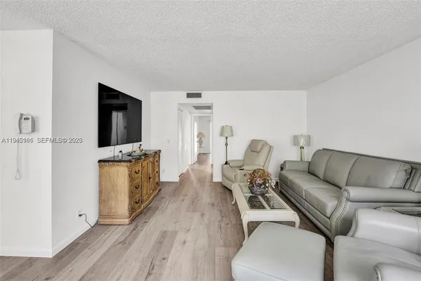 a living room with furniture a flat screen tv and a wooden floor