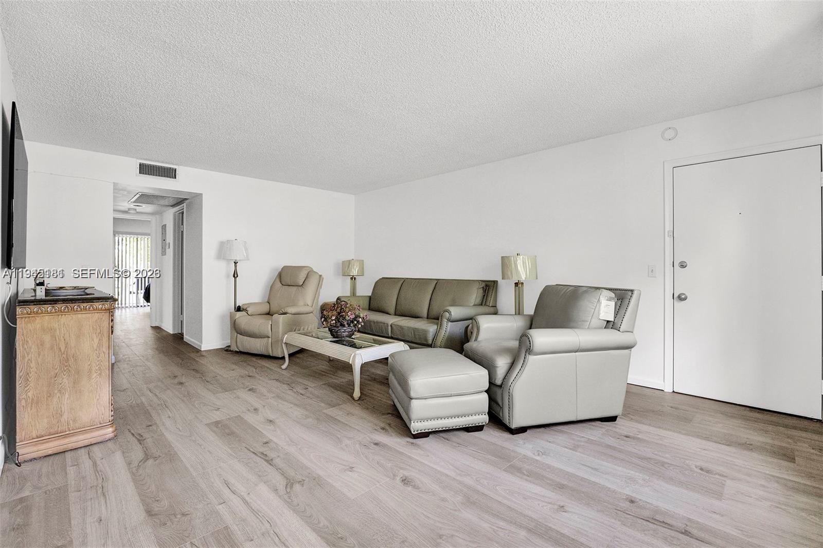 400 Southwest 134th Way, Unit 201F Pembroke Pines, FL 33027 - Photo 16 of 28 a living room with furniture and a wooden floor