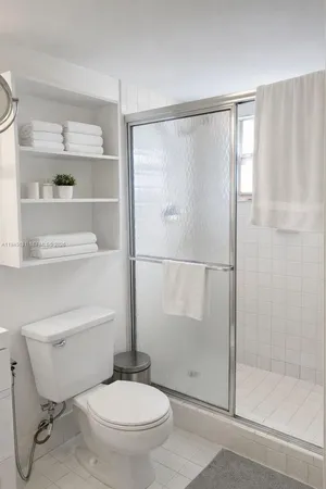 a bathroom with a toilet and a shower