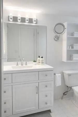 a bathroom with a double vanity sink a toilet and a mirror