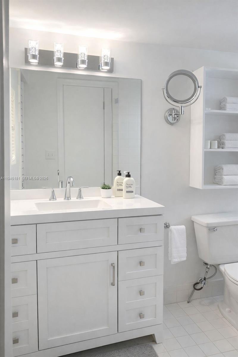 400 Southwest 134th Way, Unit 201F Pembroke Pines, FL 33027 - Photo 23 of 28 a bathroom with a double vanity sink a toilet and a mirror